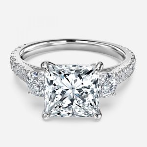 Treya princess cut white gold three stone ring, front view showing round brilliant side stones and pavé band