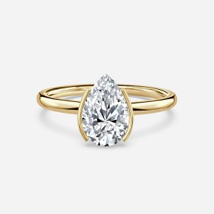 Augusta pear cut yellow gold bezel ring, front view showing east-west half bezel and plain band